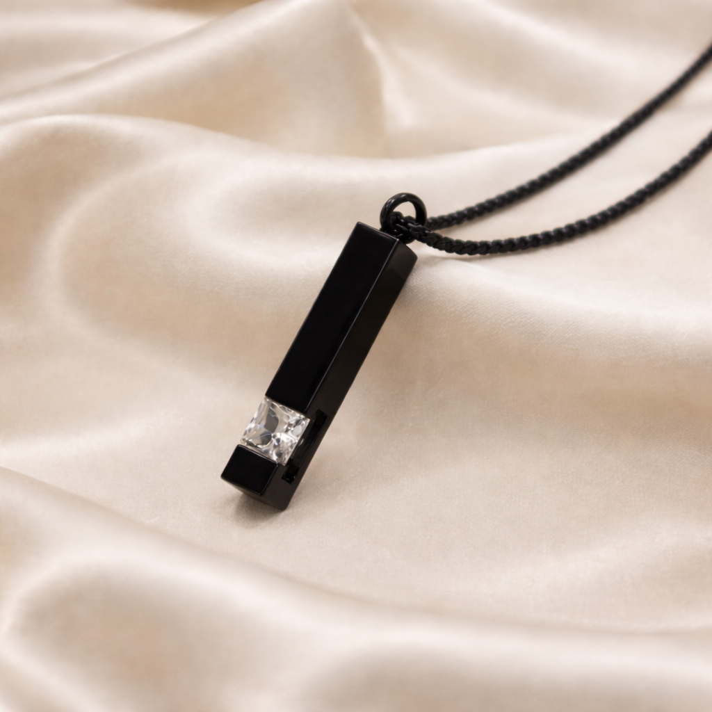 Black pendant with a diamond on a beige fabric background