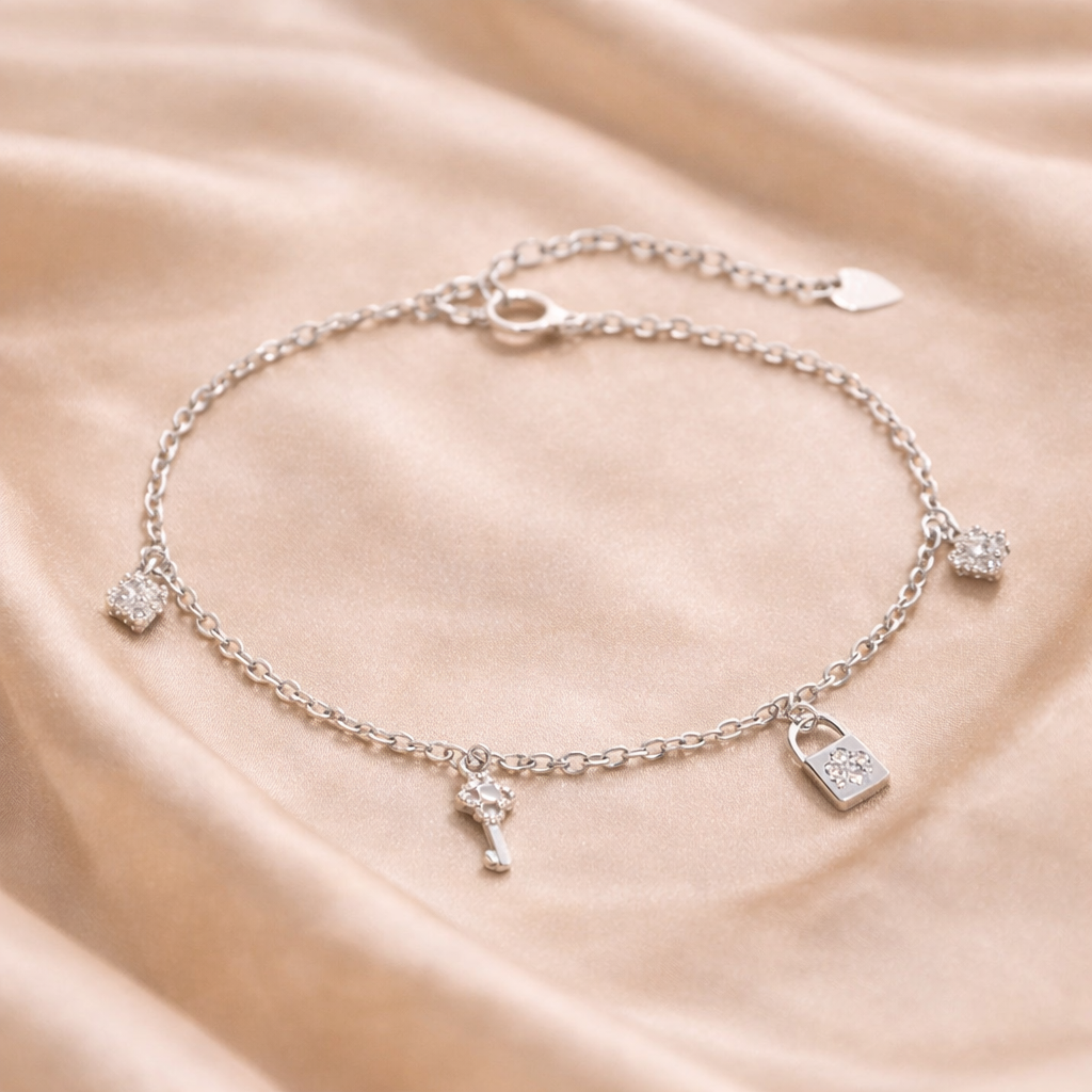 Silver bracelet with charms on a beige fabric background