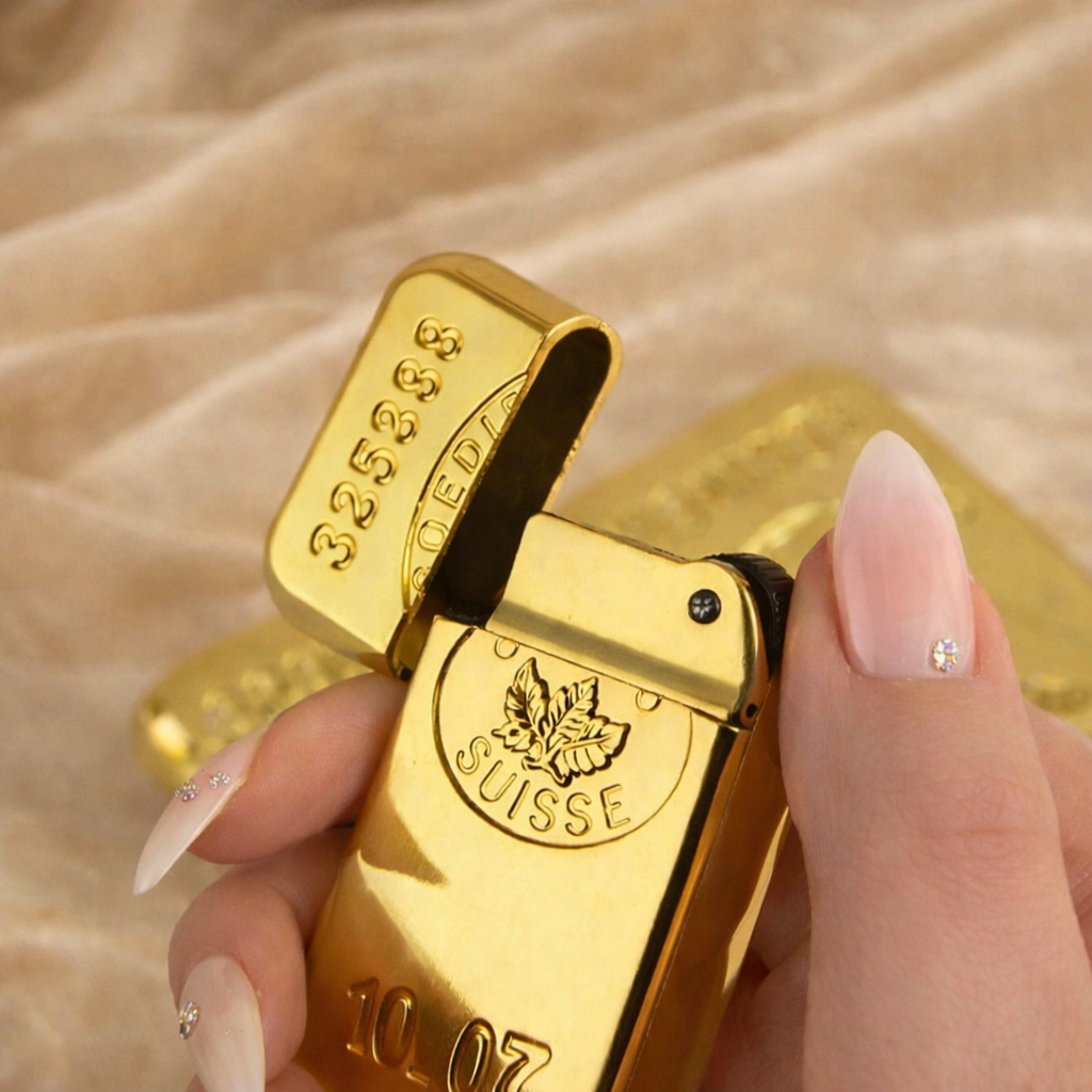 Gold lighter shaped like a Swiss gold bar held by a hand with decorative nails.