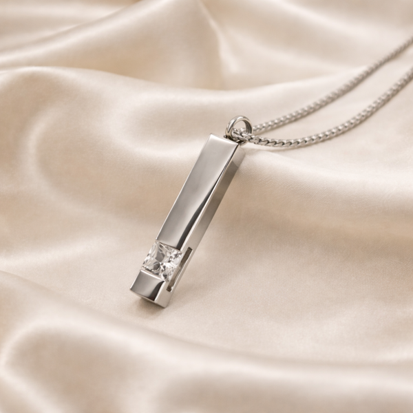 Silver pendant necklace on a beige satin background