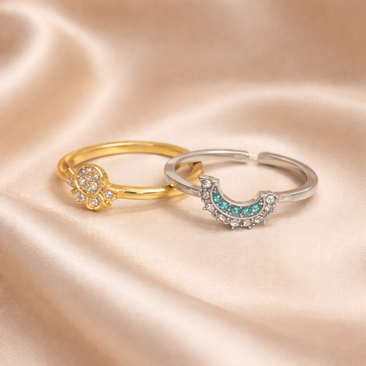 Two rings, one gold and one silver, on a satin surface