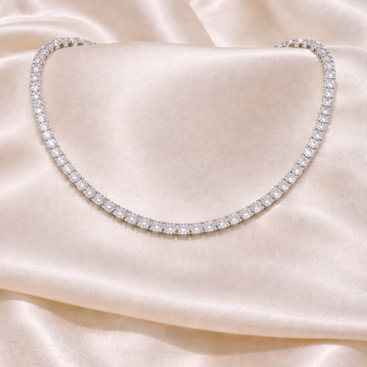 Silver necklace on a beige satin fabric