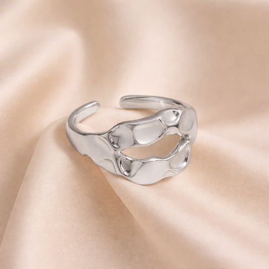 Silver ring on a beige satin background