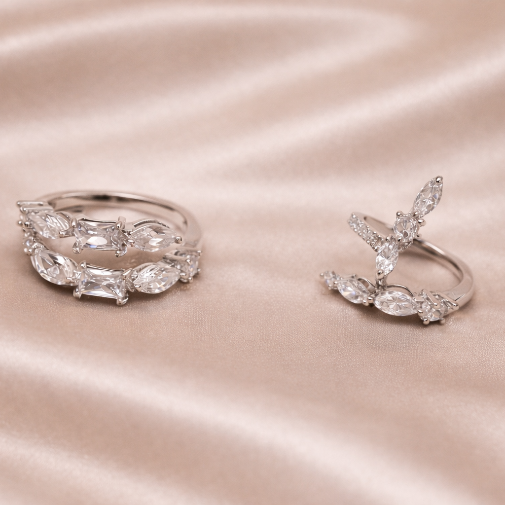 Two silver rings on a satin surface