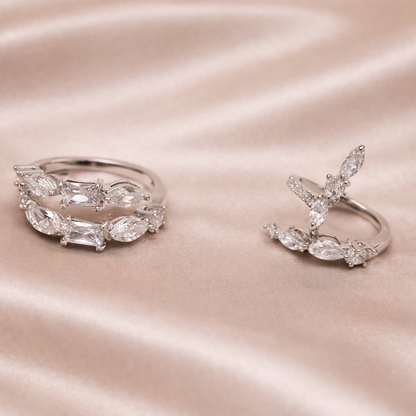 Two silver rings on a satin surface