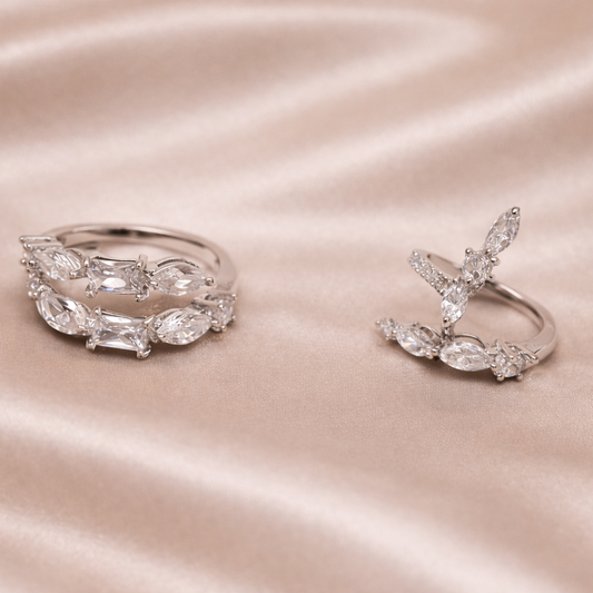 Two silver rings on a satin surface