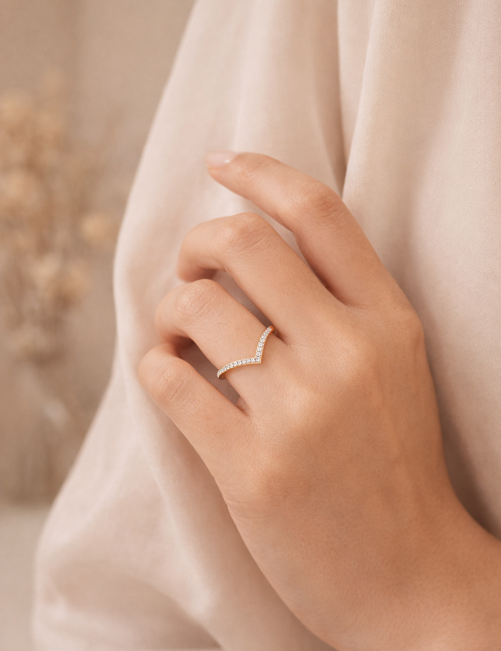 Hand wearing a diamond ring with a soft background