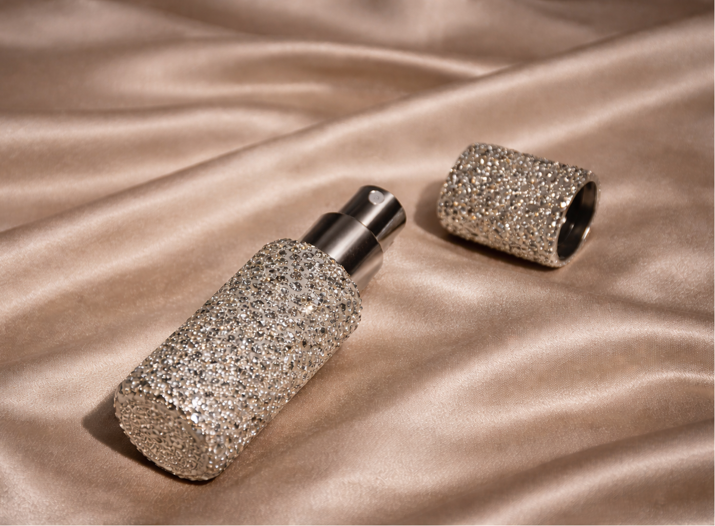Two glittery cylindrical objects on a beige fabric background