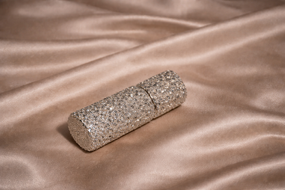Silver glittery clutch bag on a beige satin surface
