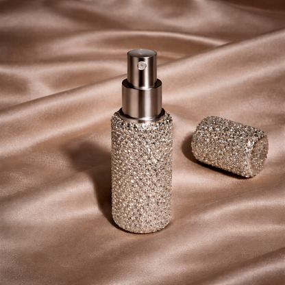 Sparkly spray bottle and roller ball on a satin surface